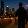 Courier delivering cannabis in Mississauga at dusk with city skyline lights